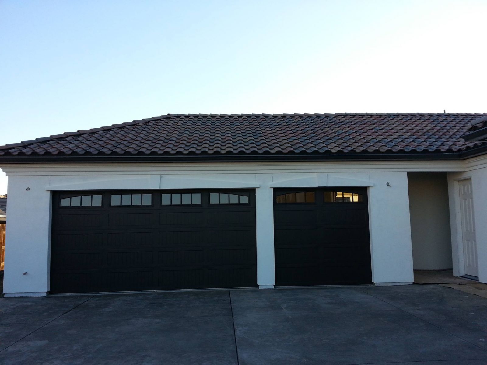 Small white home with a new black tile roof